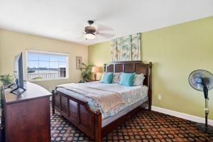 a bedroom with a bed with a fan and a window at Splash Harbour, Harbourside Waterfront Condo in Clearwater Beach +119 photos