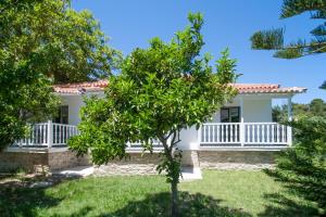 a white house with a tree in front of it at 3 Goddesses' studios in Koukounaries