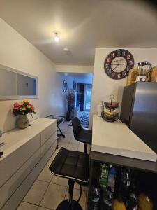 a kitchen with a counter and a clock on the wall at Chez Ismael in Melun