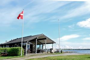a flag flying in front of a building next to the water at Tiny SeaSide - Loddenhøj in Aabenraa +25 photos