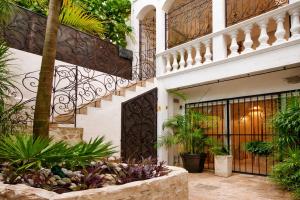 a building with a gate and a bunch of plants at Mansion Mauresque in Playa del Carmen
