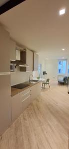 a kitchen with white cabinets and a living room at Casa Mafalda in Torre Boldone