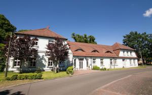 a white house with a red roof on a street at Schloss Spiegelberg in Neustadt