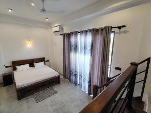 a bedroom with a bed and a large window at Calvian Villa in Walliwala East