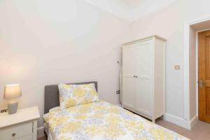 a bedroom with a bed and a white cabinet at Flat 3- The Warwick in Banbury