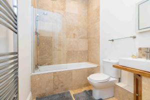 a bathroom with a toilet and a shower and a sink at Flat 3- The Warwick in Banbury