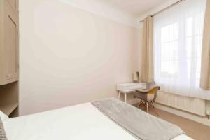 a bedroom with a bed and a desk and a window at Flat 3- The Warwick in Banbury