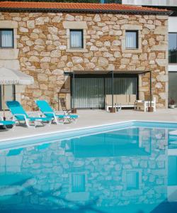 a swimming pool with chairs and a house at Sandoco - Golf - Pickleball - Beach Volleyball & Pool - All Exclusive in Ponte de Lima