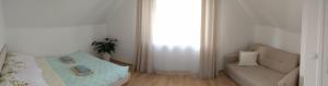 a bedroom with a bed and a couch and a window at Domek Na Klinie in Jastrzębia