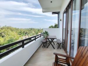 a balcony with a table and benches on it at Calvian Villa in Walliwala East