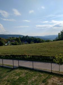 a fence with a view of a field at Domek Na Klinie in Jastrzębia +10 photos