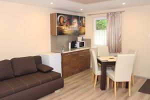 a living room with a couch and a table and a kitchen at BB Apartman in Villány