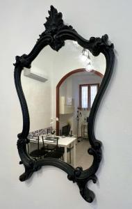 a mirror on a wall with a table in a room at Porto Vecchio Apartment in Sanremo