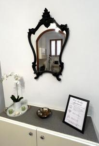 a mirror on a wall above a dresser at Porto Vecchio Apartment in Sanremo
