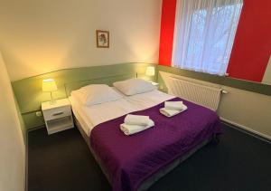 a bedroom with a bed with two towels on it at Hotel Flora in Łódź