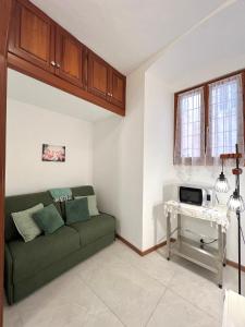 a living room with a green couch and a table at Porto Vecchio Apartment in Sanremo