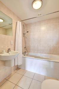 a bathroom with a tub and a sink and a shower at 2 Bed in Swanage oc-wy412 in Swanage