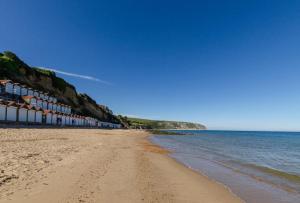 a sandy beach with buildings and the ocean at 2 Bed in Swanage oc-wy412 in Swanage