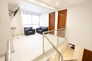 a living room with two chairs and a staircase at Casa completa, 5 dormitorios y jardín in Ayacucho