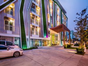 a white car parked in front of a building at Atelier Suites in Bangkok