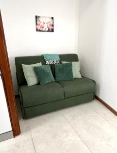 a green couch sitting in a living room at Porto Vecchio Apartment in Sanremo +23 photos
