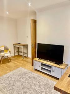 a living room with a flat screen tv on a stand at Flat 8- Garden Square in Banbury