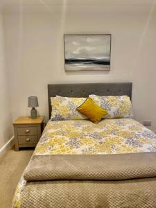 a bedroom with a bed with a yellow pillow at Flat 8- Garden Square in Banbury