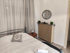 a bedroom with a white bed and a mirror at A & P Apartment in Xanthi