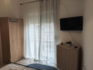 a living room with a large window with a television at A & P Apartment in Xanthi