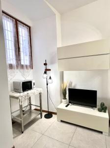 a living room with a tv and a microwave at Porto Vecchio Apartment in Sanremo