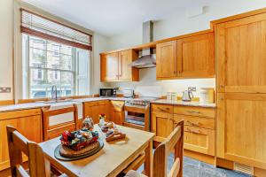 Eine Küche mit Holzschränken und ein Tisch mit einer Obstschale. in der Unterkunft 2 Bed in Alnwick oc-f28915 in Alnwick + 16 Fotos