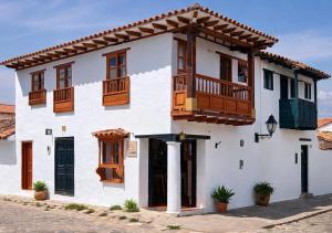 a white house with wooden windows and a balcony at Boutique La Gloria in Villa de Leyva