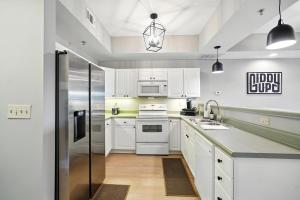 a kitchen with white cabinets and a stainless steel refrigerator at New 2 Bed 2 Bath Condo with Pool at BMS in Bristol