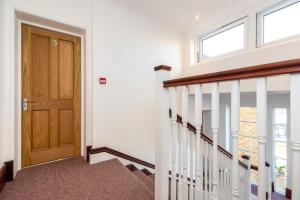 a hallway with a staircase with a wooden door at Flat 9- Park Place in Banbury