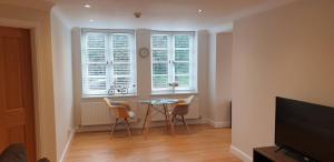 a living room with a table and chairs and a window at Flat 9- Park Place in Banbury