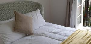 a white bed with a pillow and a window at Flat 9- Park Place in Banbury