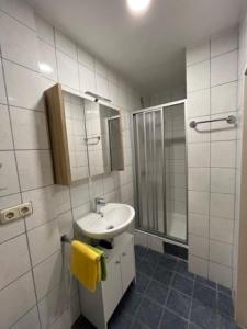 a white bathroom with a sink and a shower at Ferienhaus Schiemel in Altmünster +50 photos