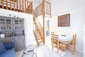 a kitchen and dining room with a table and stairs at LES MARINES 2 - Villa en résidence avec piscine à 2 pas de la plage - Clim - parking in Saint-Cyprien