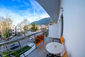 a balcony with a table and a view of a city at Hotel Ena - Elegant Mountain View Stay with Pool in Loutra Ipatis