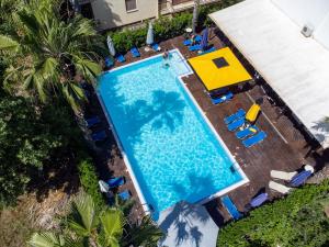 an overhead view of a swimming pool with chaise lounge chairs and a resort at Hotel Ena - Elegant Mountain View Stay with Pool in Loutra Ipatis