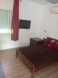 a bedroom with a bed and a flat screen tv at Suite in nice résidence in Rabat
