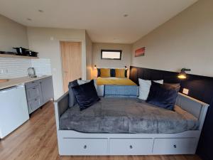a bedroom with a large bed and a kitchen at Lothmore Lookout - Sunrise in Kilmote