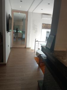 a living room with a fireplace and a person in the hallway at Suite in nice résidence in Rabat