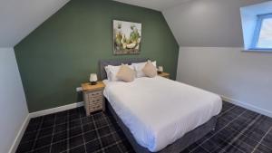 a bedroom with a white bed and a green wall at Woodside House in Crook of Alves +72 photos