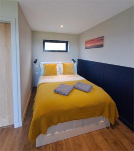 a bedroom with a bed with a yellow blanket at Lothmore Lookout - Sunrise in Kilmote +21 photos
