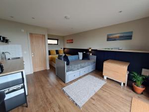 a living room with a couch and a bed at Lothmore Lookout - Sunrise in Kilmote