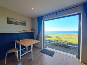 a room with a table and a large sliding glass door at Lothmore Lookout - Sunrise in Kilmote