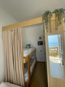 a room with two bunk beds and a door to a balcony at Apartament Mare e Sole z basenem i przy plaży in Marotta +31 photos
