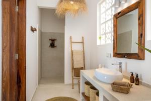 a bathroom with a sink and a mirror at Coconut Villas Zanzibar in Matemwe +23 photos