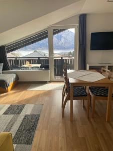 a living room with a table and a large window at Ferienhaus Schiemel in Altmünster